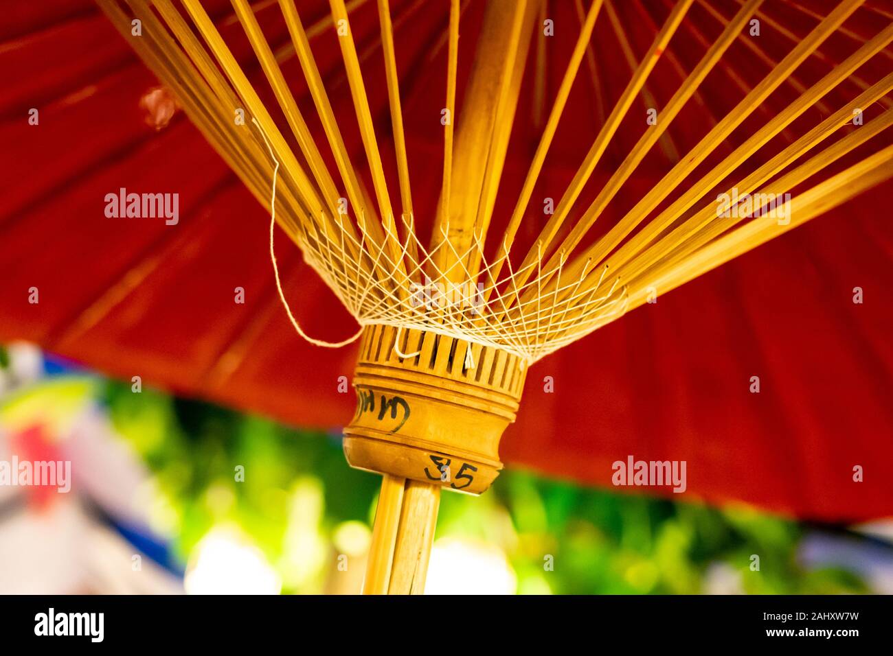 Fatto a mano colorato di rosso tradizionale ombrellone con bambù raggi guardando dal di sotto. Fotografia: Iris de Reus Foto Stock