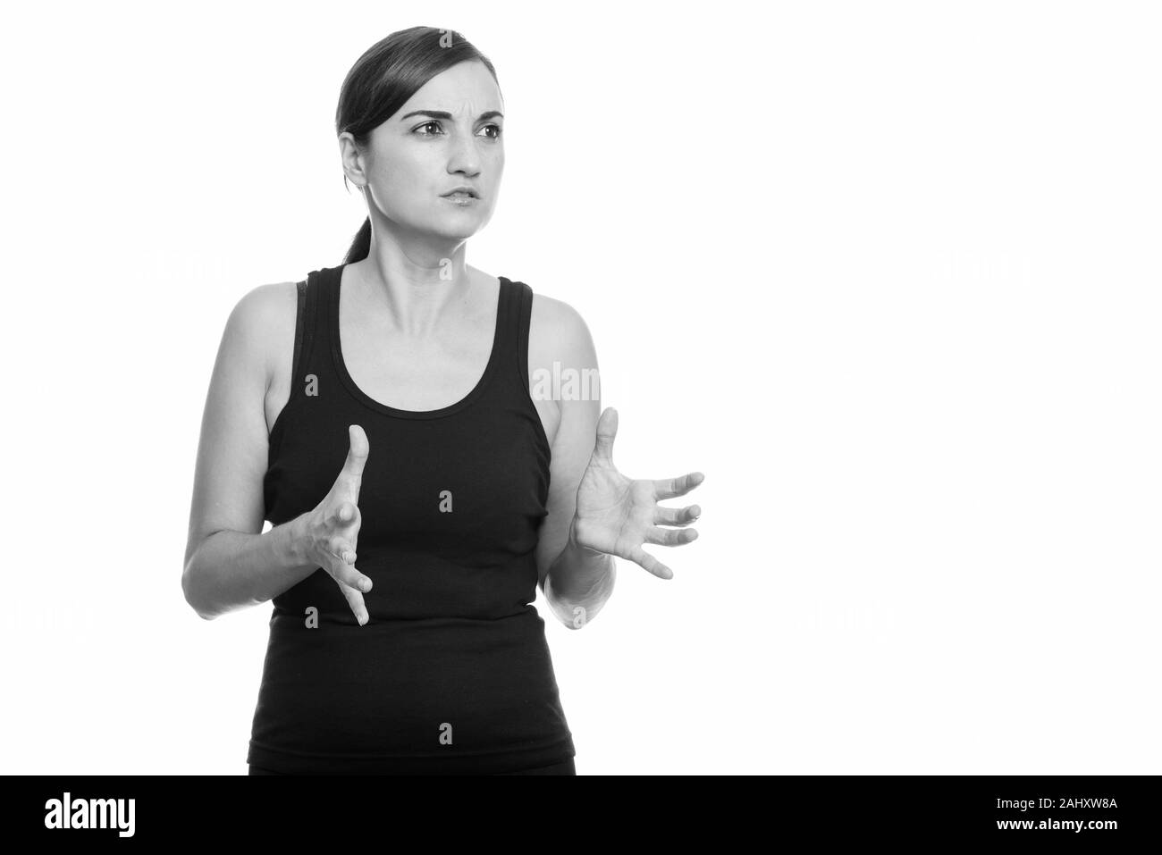 Studio shot di bella donna che guarda furioso con entrambe le mani sollevate Foto Stock