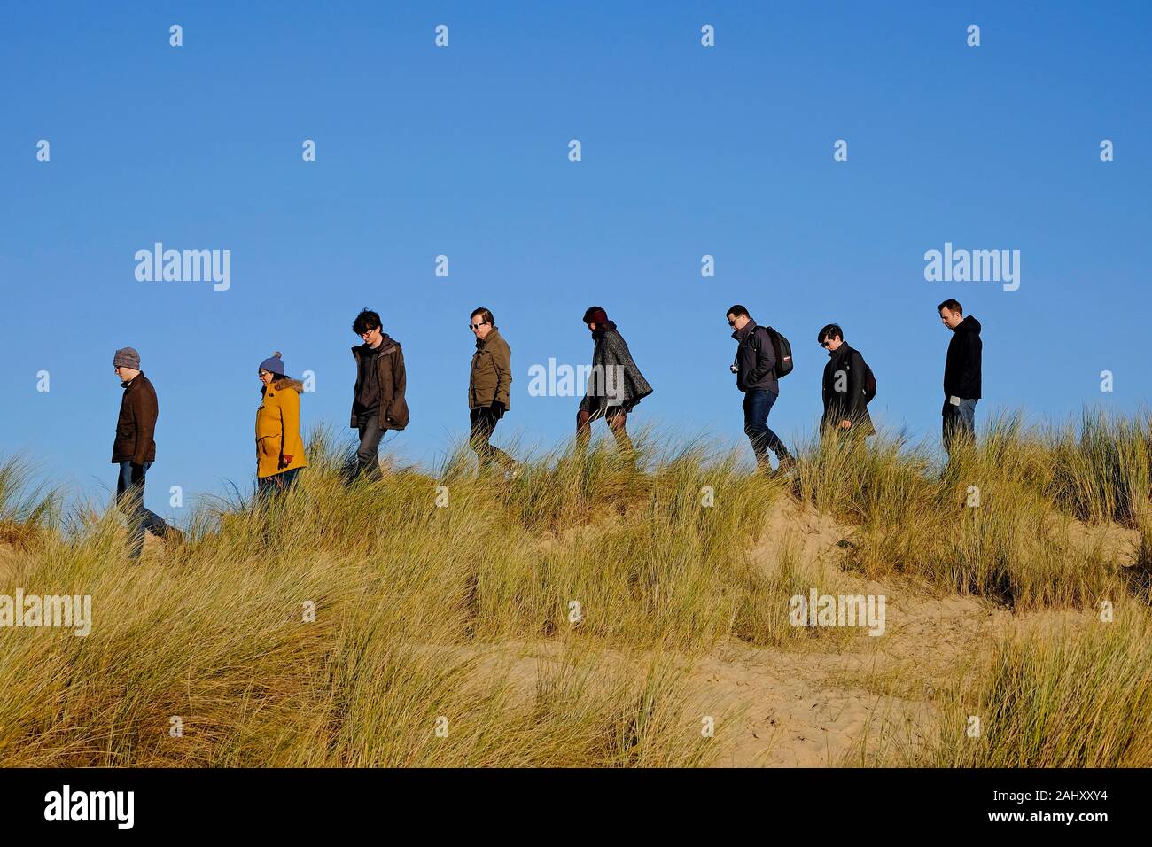 La gente camminare sulle dune di sabbia sulla spiaggia di holkham, North Norfolk, Inghilterra Foto Stock