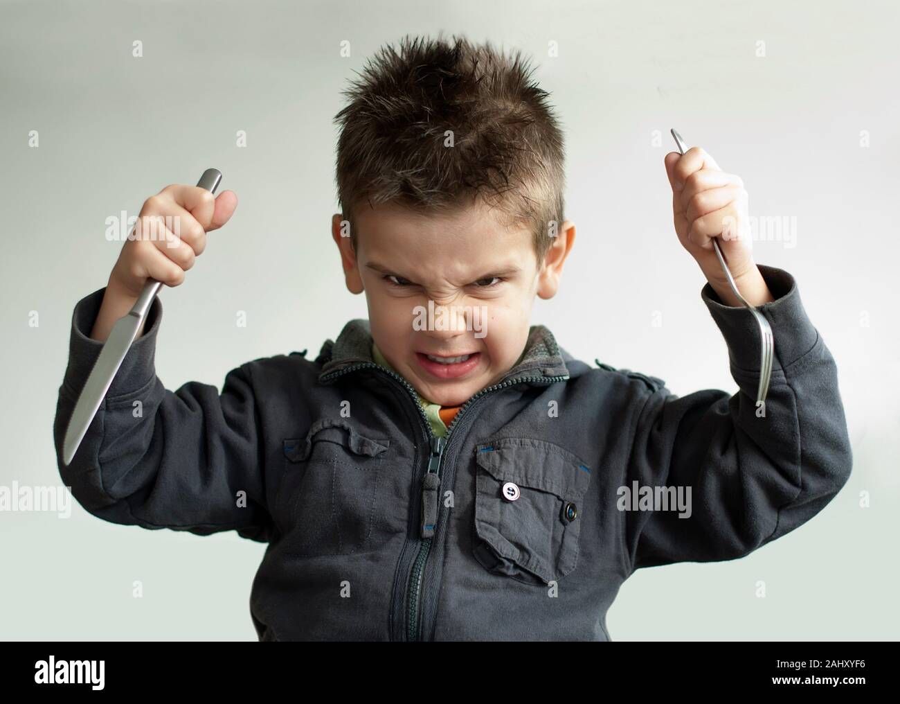 Bambino con un coltello e forchetta. Close up Foto stock - Alamy