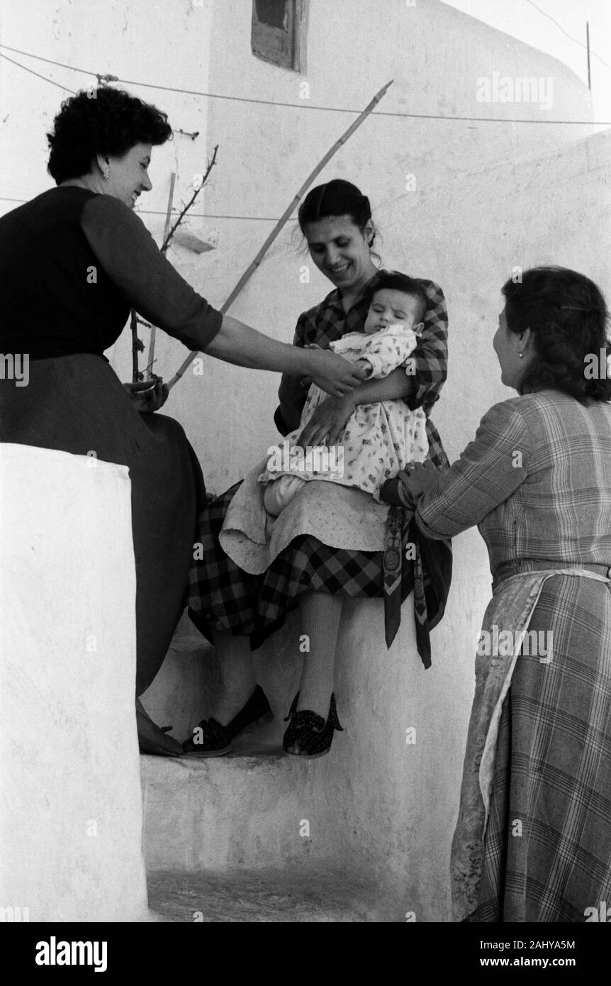 Drei Frauen und ein Baby sitzen un einer Treppe in Mykonos, Griechenland 1950er. Tre donne e un bambino seduto a una scala a Mykonos, Grecia negli anni cinquanta. Foto Stock