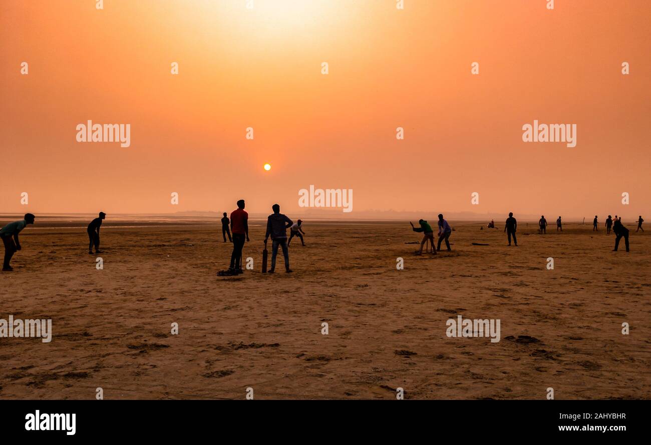 Silhouette di persone , giocare a cricket al momento del tramonto su una spiaggia. Foto Stock