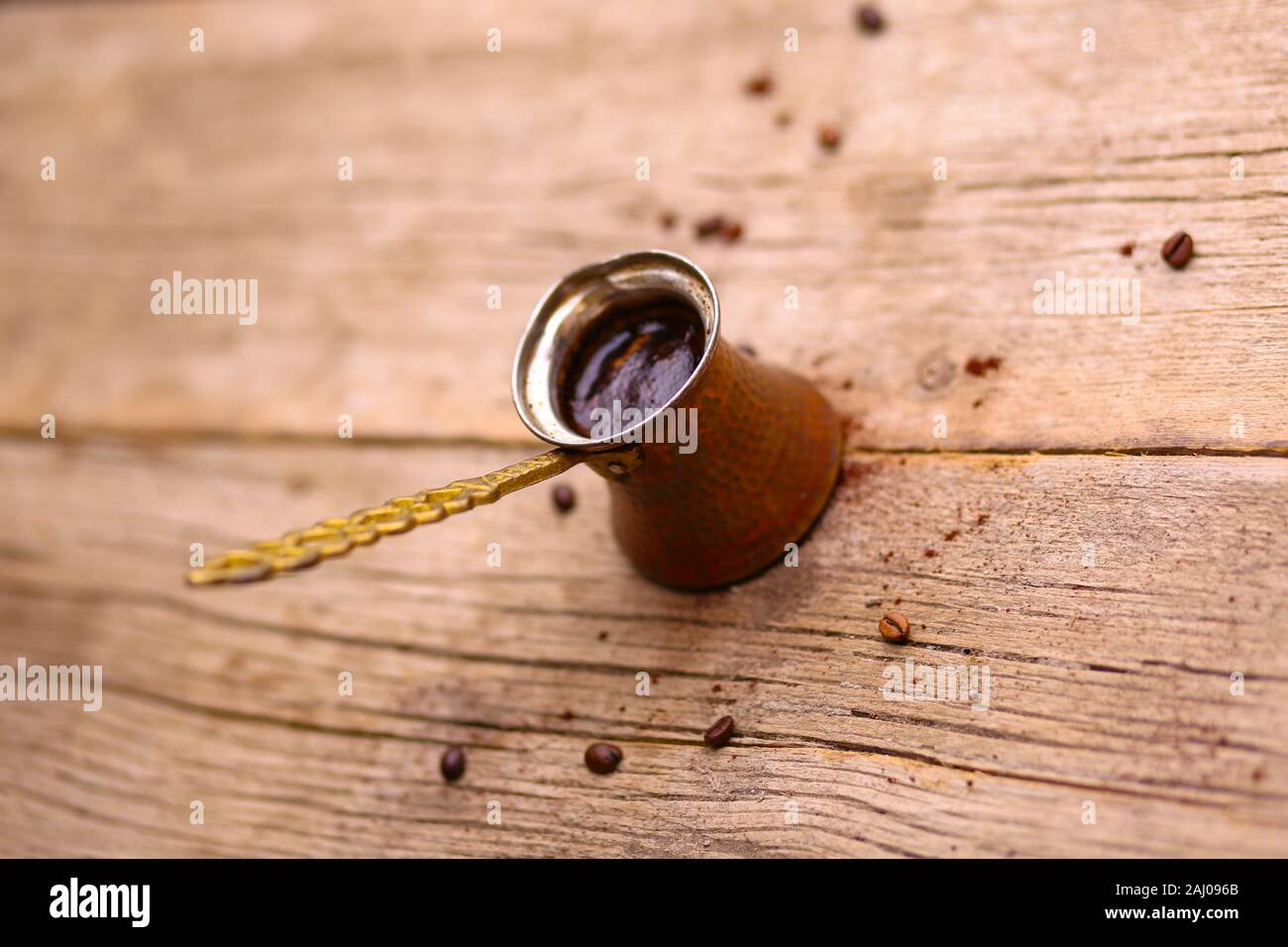 Bagno turco o caffè arabo su vintage tavolo in legno con diffusione i chicchi di caffè in un metallo bollitore per caffè Foto Stock