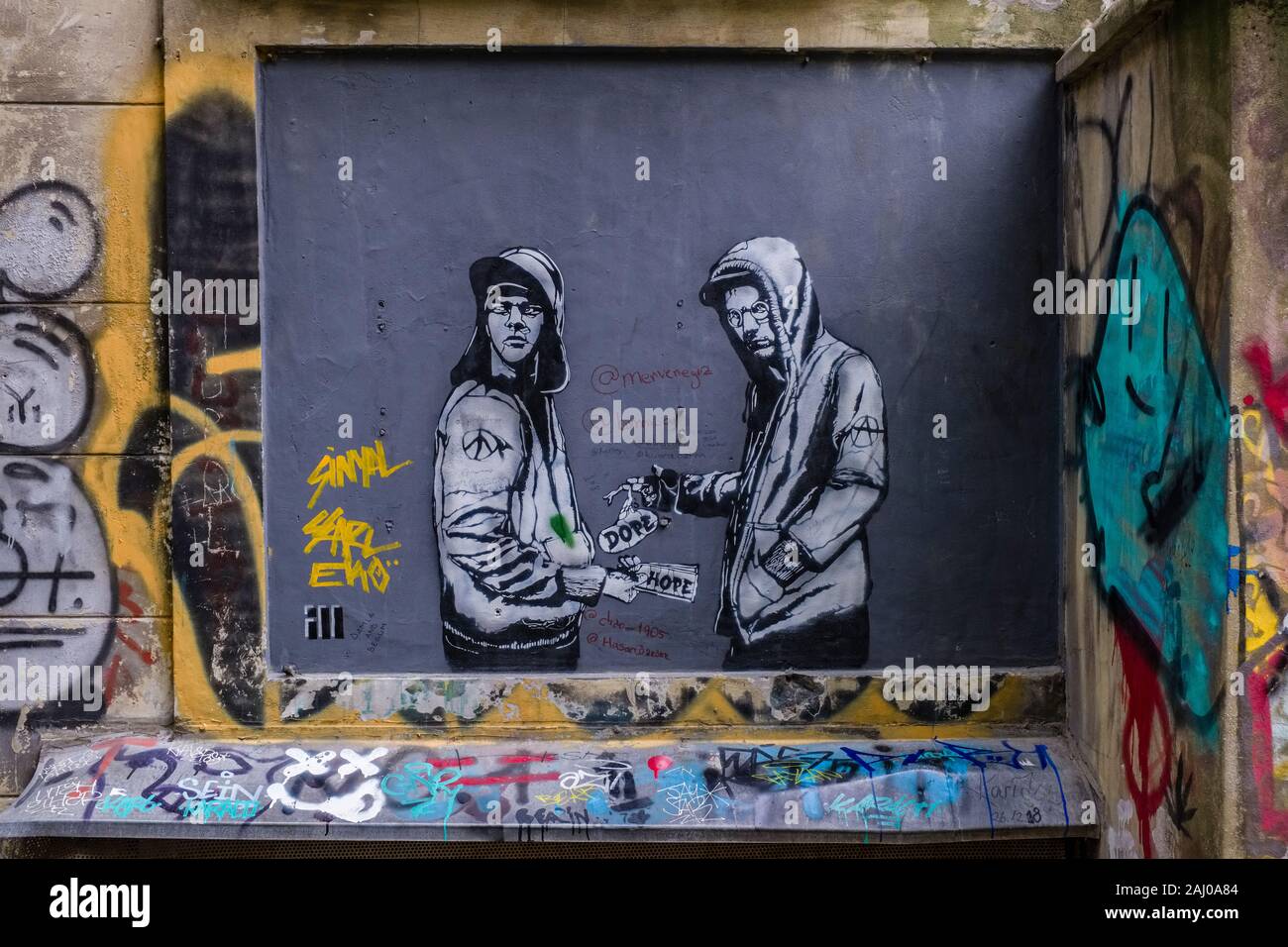 Facciata di una casa con graffity di due uomini che si occupano di droga viene spruzzato su nel sobborgo Karaköy Foto Stock