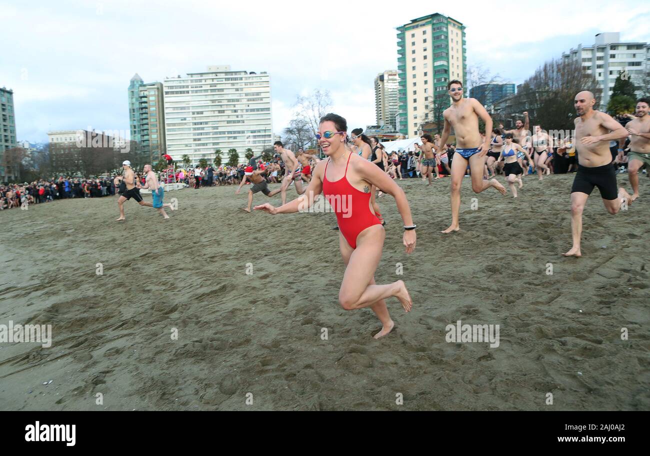 Vancouver, Canada. 1a gen, 2020. La prima ondata di giorno di nuovi anni di festeggianti gara per le fredde acque di English Bay durante il centesimo annuale Orso Polare nuotare in Vancouver, British Columbia, 1 gennaio 2020. Circa 6000 persone hanno partecipato nel 2020 Giorno di nuovi anni nuotare, oltre il doppio del record precedente, contribuendo a rendere il Vancouver Polar Bear club uno dei più grandi e più antiche del mondo. Foto di Heinz Ruckemann/UPI Credito: UPI/Alamy Live News Foto Stock