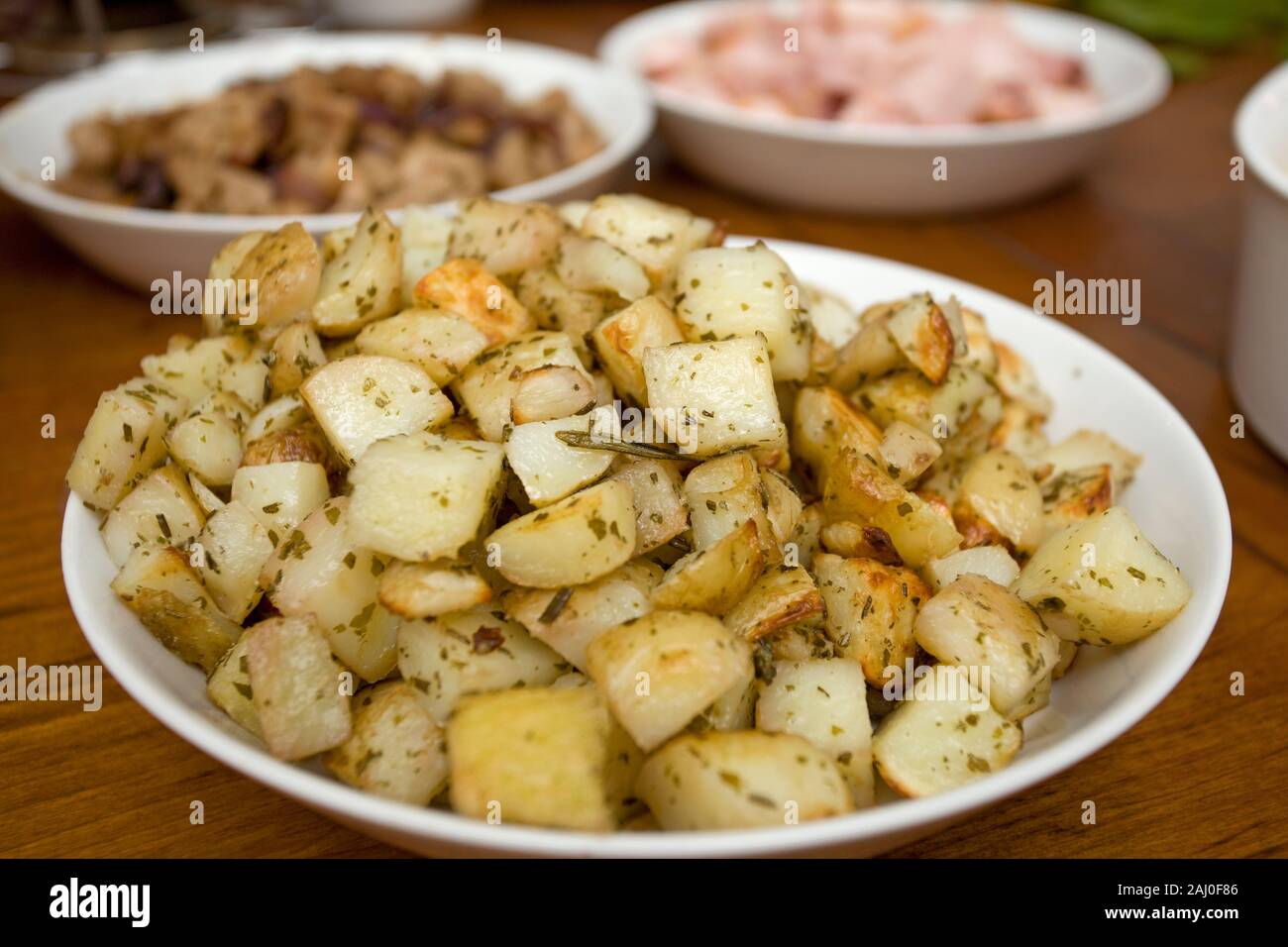 Una piastra di leggermente tostate square di patate con il condimento Foto Stock