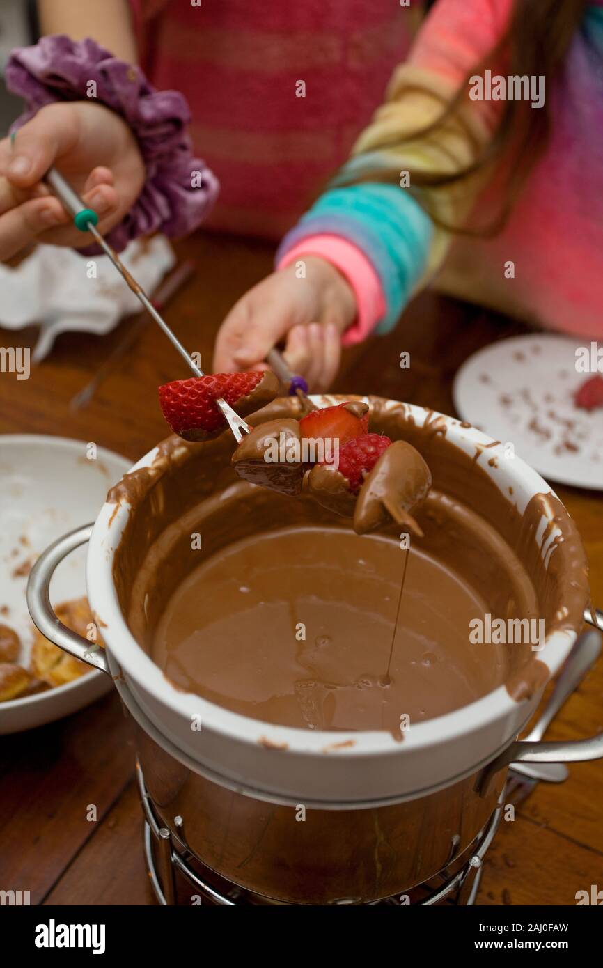 I bambini a mangiare la fonduta di cioccolato Foto Stock