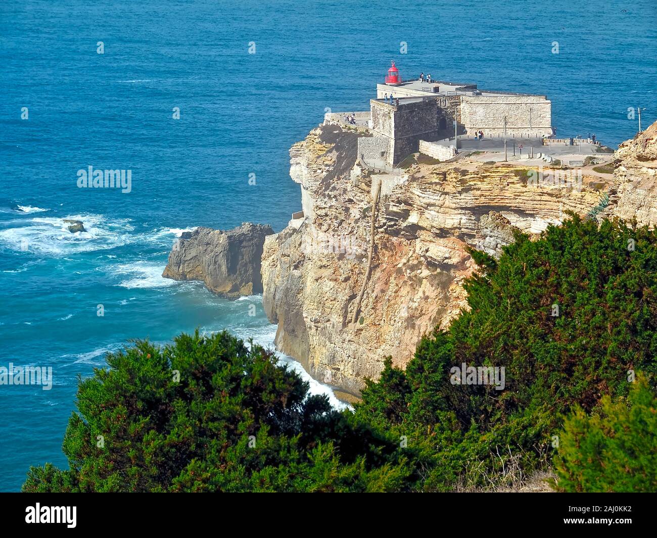 Il famoso faro a Nazare in Portogallo circondata dall'oceano Atlantico Foto Stock