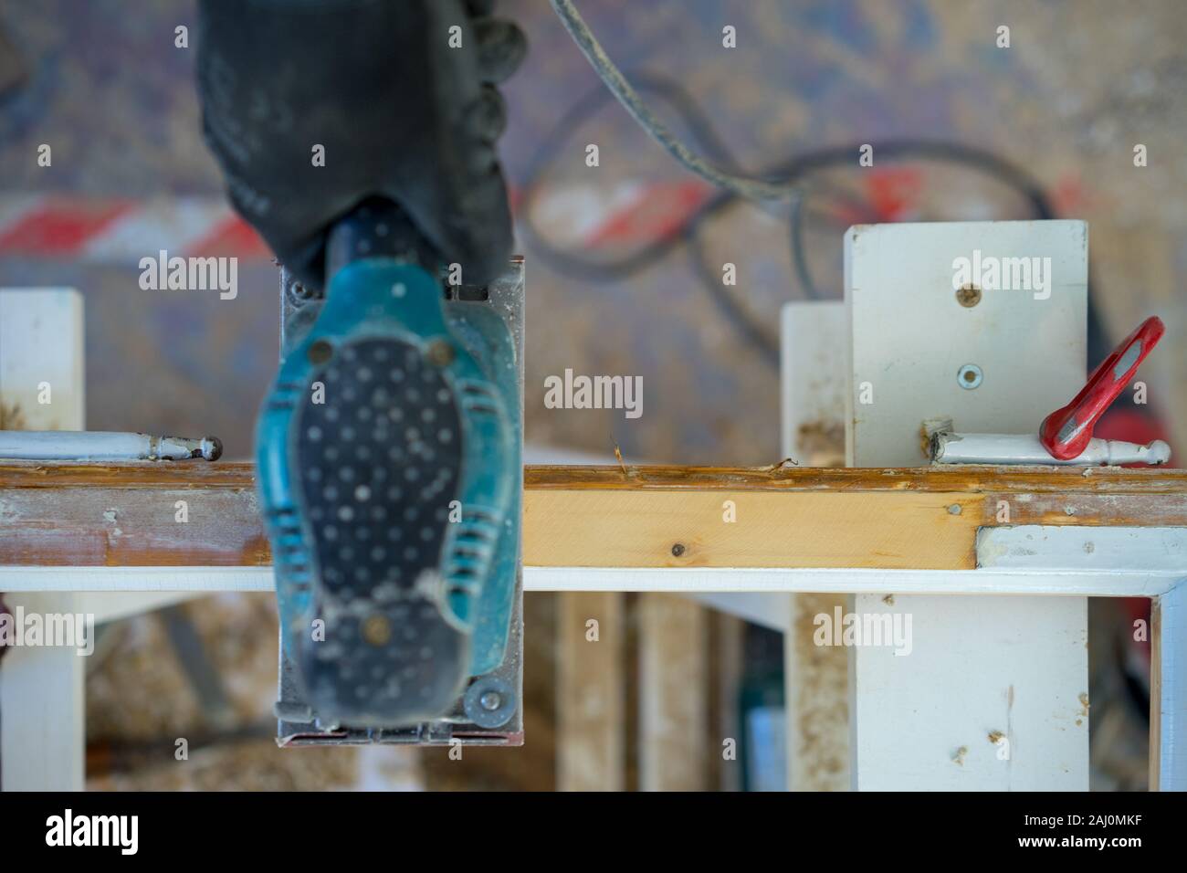 Macinazione di lucidatura a mano una cornice di legno con una macchina Foto Stock