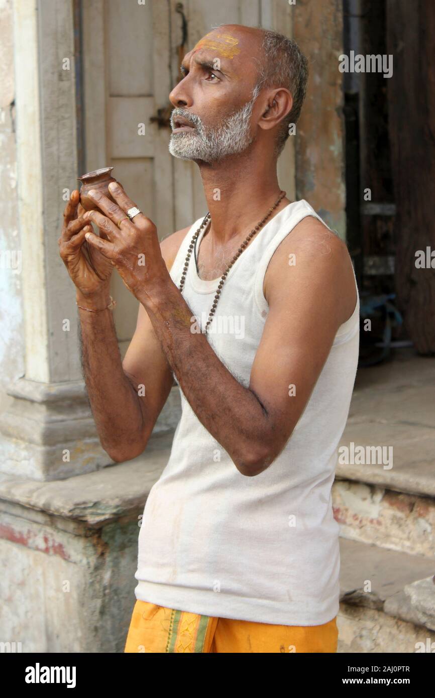 Uomo di eseguire una puja al di fuori di casa sua, Old Ahmedabad, Gujarat, India Foto Stock