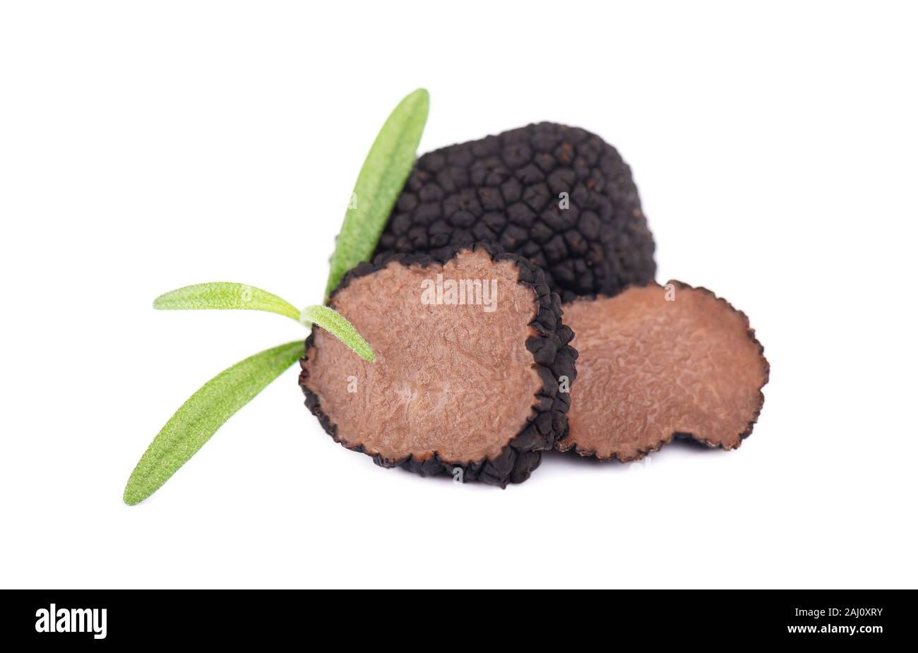 I tartufi neri isolati su uno sfondo bianco. Freschi fette di tartufo con il ramo di rosmarino. Delicatezza esclusiva fungo tartufo. Formaggi piccanti e fragrante Foto Stock