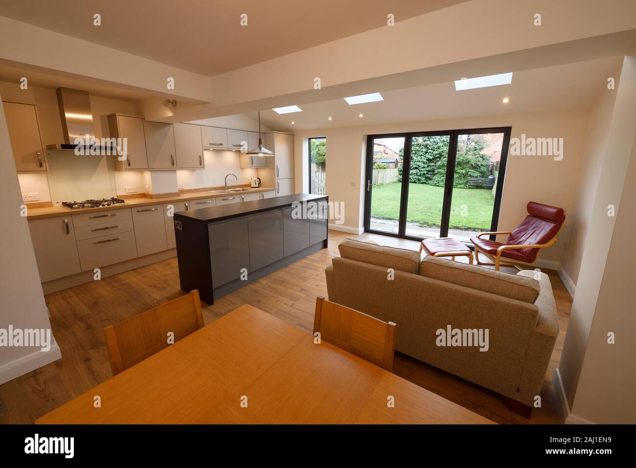 Un moderno open plan cucina sala da pranzo soggiorno prolungamento posteriore a una proprietà in Chester con portafoglio porte e lucernari velds Foto Stock