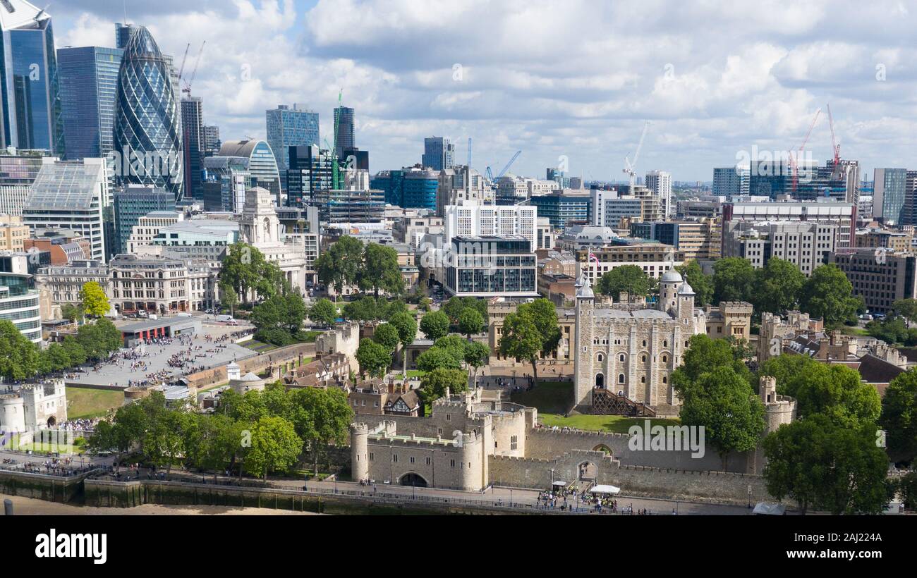 Torre di Londra nel centro della città circondata da alberi E edifici di architettura moderna come il grattacielo Gherkin Foto Stock