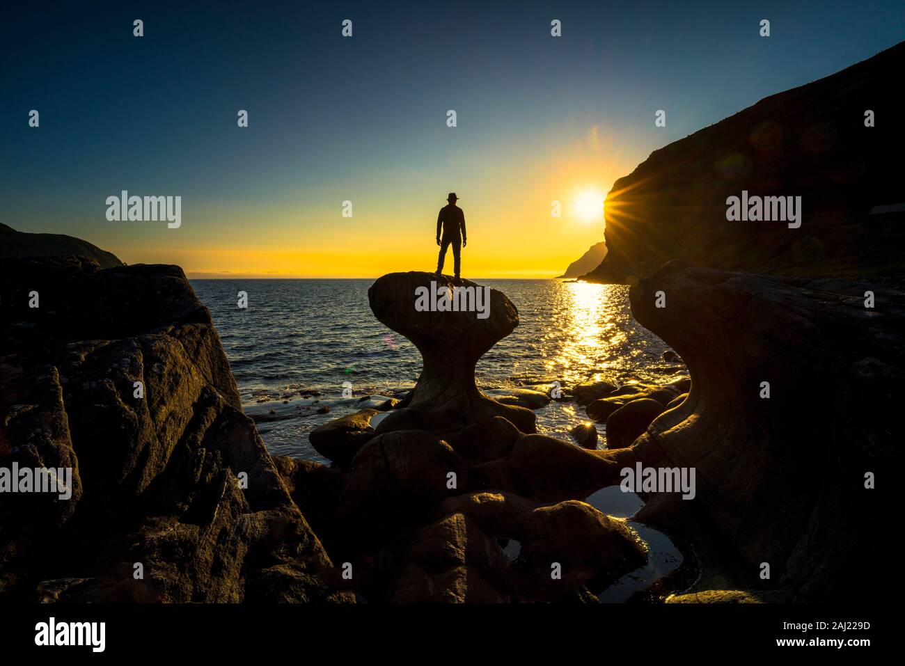 Silhouette di uomo ammirando il tramonto permanente sulla cima della roccia Kannesteinen, Oppedal, Vagsoy, Sogn og Fjordane county, Norvegia, Scandinavia, Europa Foto Stock