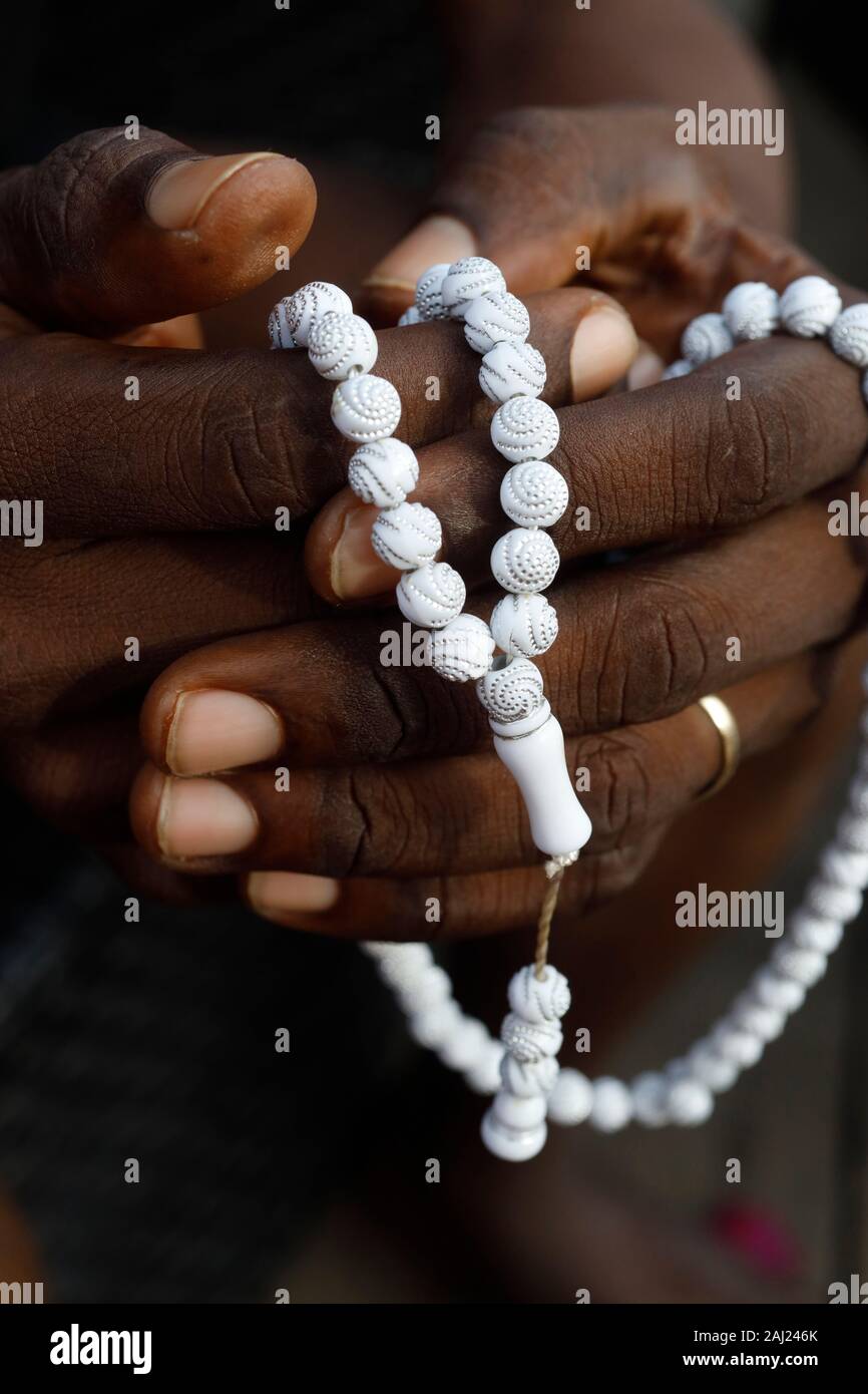 Close-up di mani di musulmani africani uomo che prega con la preghiera islamica talloni (tasbih), Togo, Africa occidentale, Africa Foto Stock