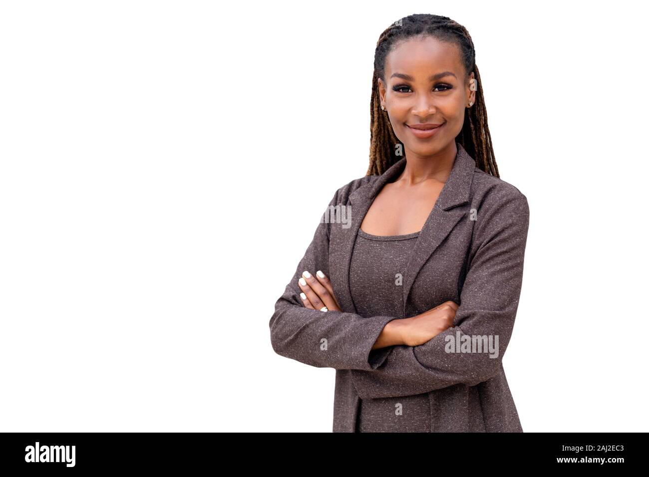 Bellissima femmina african american business woman CEO in una tuta, isolato su sfondo bianco, tranquillamente in piedi con le braccia incrociate Foto Stock