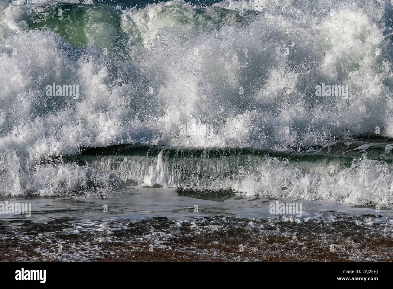 Schiumoso onda atlantico si infrangono sulla costa. Foto Stock