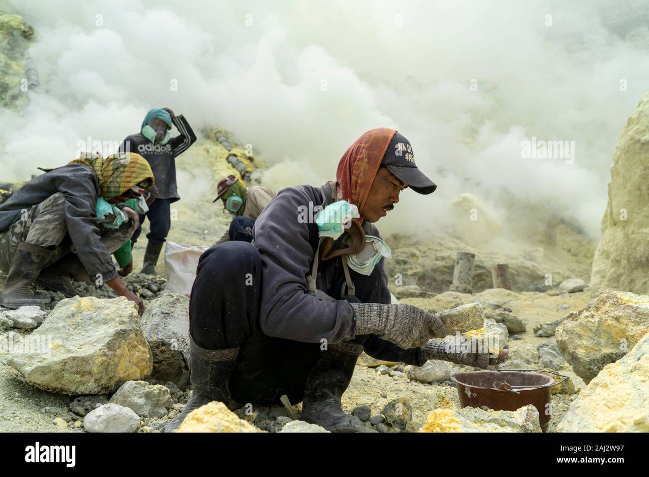 Ricerca dei minatori per lo zolfo presso il cratere del vulcano Ijen.Il vulcano Ijen è uno dei pochi luoghi in cui lo zolfo è ancora minate senza macchine, il cratere di vulcano ha una bocca attiva che produce zolfo elementare. La respirazione nel gas di zolfo può provocare a lungo termine le implicazioni sanitarie ma nonostante ciò non vi è carenza di minatori locali disposti a rischiare tutto per guadagnare un buon stipendio, minatori fare un reddito medio di tre volte superiore al salario locale. Zolfo puro viene utilizzato nella famiglia di prodotti per la pulizia, il make up, esplosivi e purificazione di zucchero. Il vulcano attrae anche turi Foto Stock