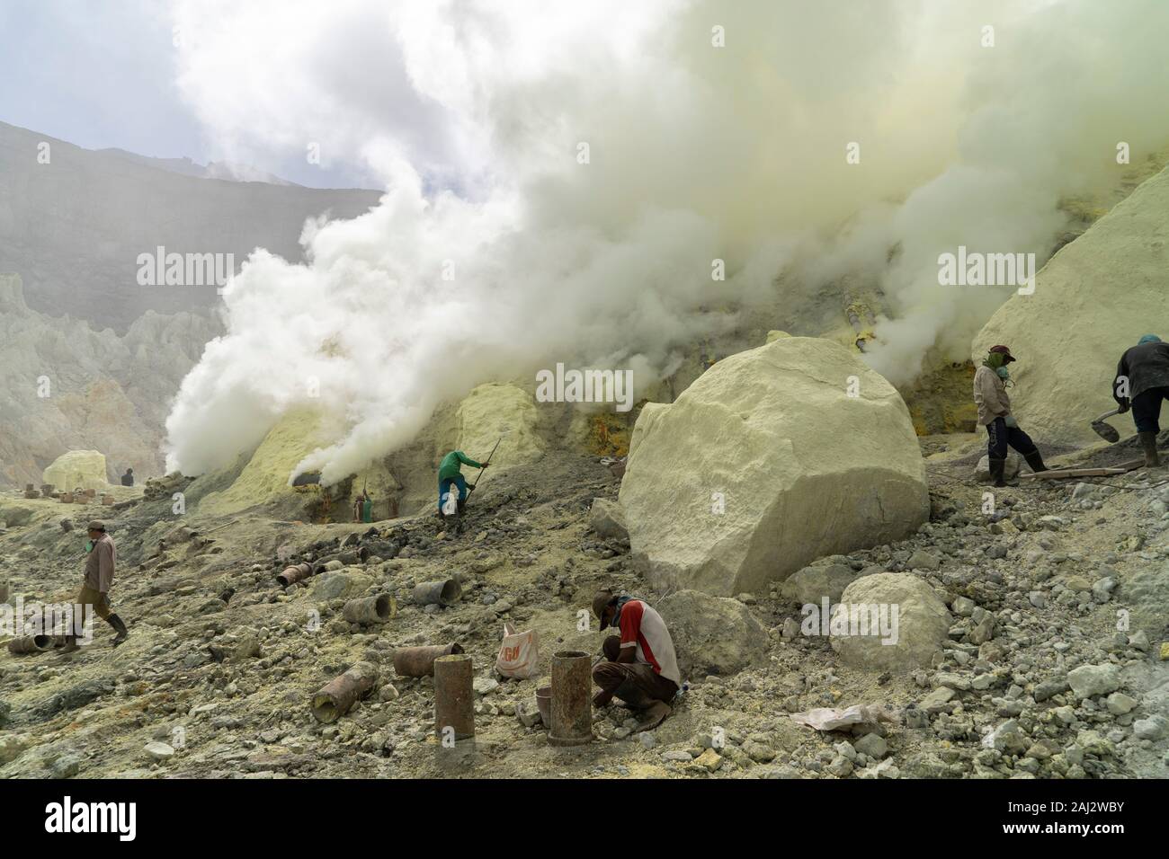 Ricerca dei minatori per il tenore di zolfo nel cratere del vulcano Ijen.Il vulcano Ijen è uno dei pochi luoghi in cui lo zolfo è ancora minate senza macchine, il cratere di vulcano ha una bocca attiva che produce zolfo elementare. La respirazione nel gas di zolfo può provocare a lungo termine le implicazioni sanitarie ma nonostante ciò non vi è carenza di minatori locali disposti a rischiare tutto per guadagnare un buon stipendio, minatori fare un reddito medio di tre volte superiore al salario locale. Zolfo puro viene utilizzato nella famiglia di prodotti per la pulizia, il make up, esplosivi e purificazione di zucchero. Il vulcano attrae anche turi Foto Stock