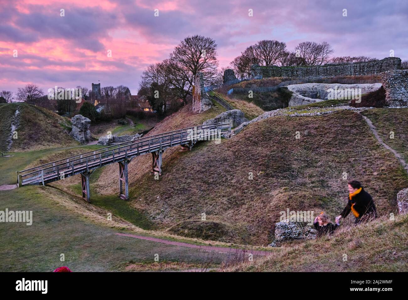 Drammatica vivid dicembre il tramonto del XI secolo i ruderi del castello di Acri fortificazioni nel Norfolk, Inghilterra Foto Stock