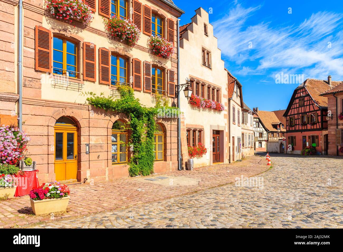 Belle facciate di case decorate con fiori sulla strada del villaggio di Bergheim, Alsazia strada del vino, Francia Foto Stock