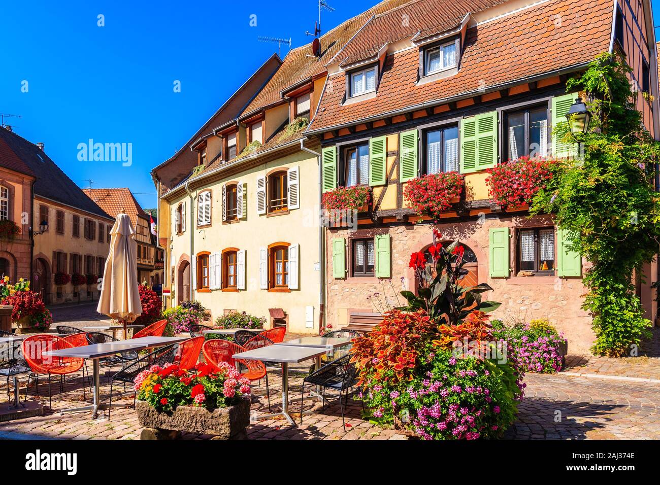 Tavole di ristorante sulla piazza del villaggio di Kintzheim che si trova sulla famosa strada dei vini di Alsazia, Francia Foto Stock