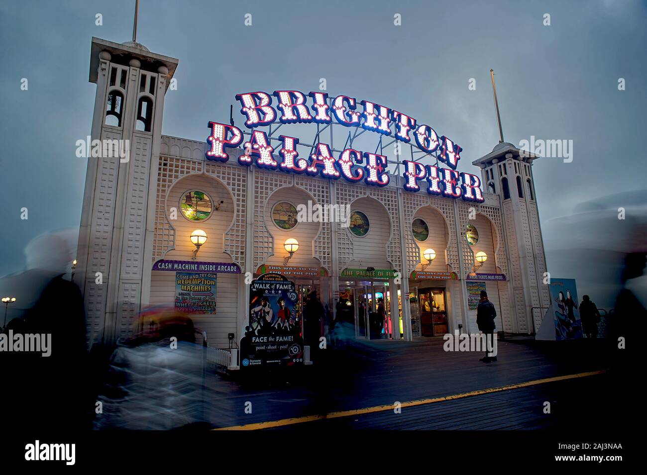 L'insegna illuminata del Brighton Palace Pier è illuminata al tramonto. Il famoso molo di Brighton è una delle attrazioni turistiche più popolari del Regno Unito Foto Stock