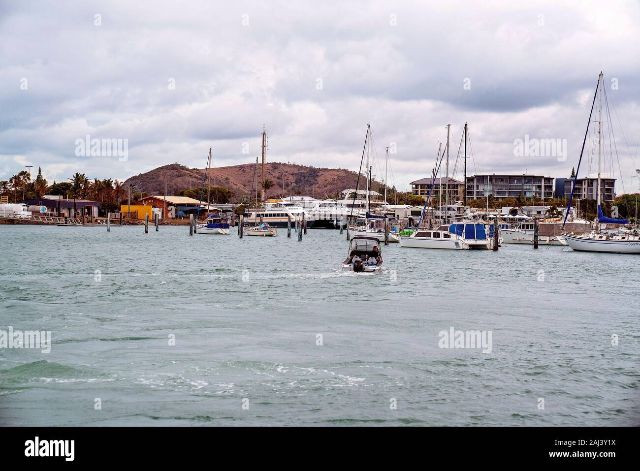 Yamba, Queensland, Australia - Dicembre 2019: una barca veloce con un pescatore a bordo capi torna nella marina dopo una giornata fuori sull'oceano Foto Stock