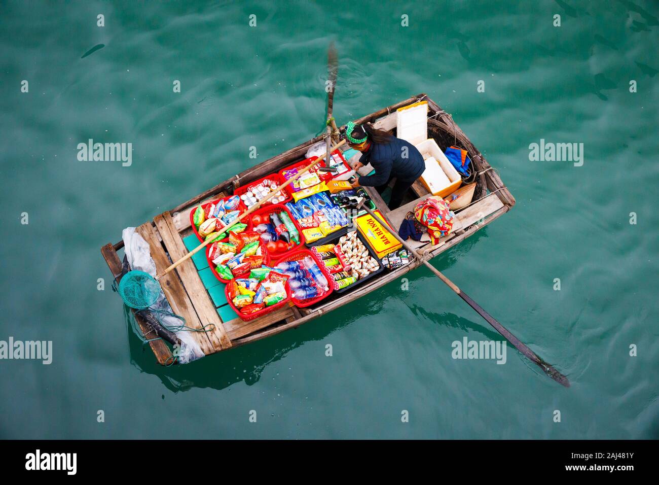 Vendite flottante persone avvicinando le navi da crociera che vendono merci - la Baia di Ha Long, Ha Long, Vietnam Foto Stock