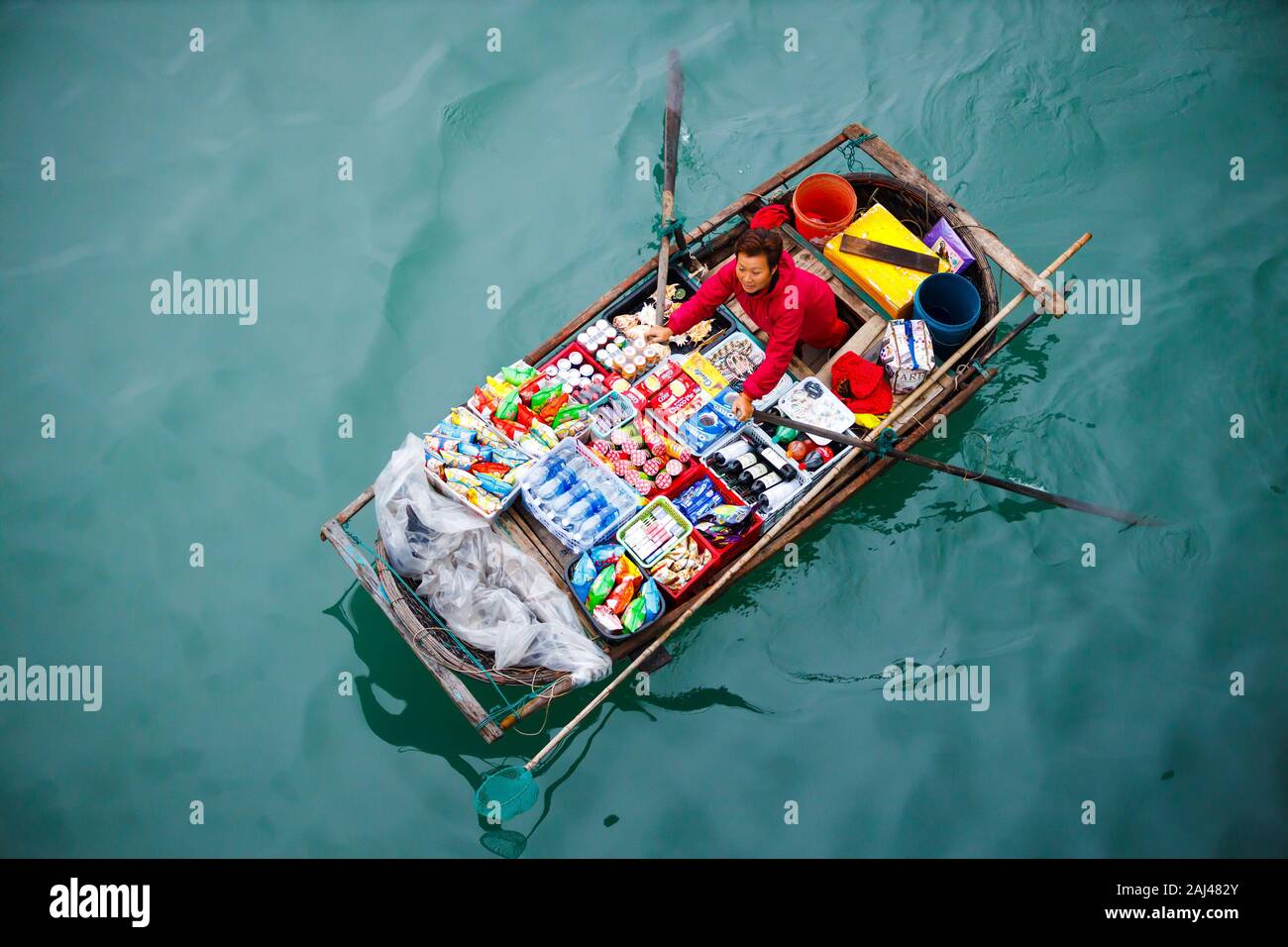 Vendite flottante persone avvicinando le navi da crociera che vendono merci - la Baia di Ha Long, Ha Long, Vietnam Foto Stock