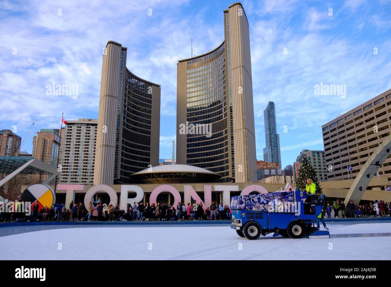 Pulizia di ghiaccio macchina su pista di pattinaggio di fronte iconico segno di Toronto a New City Hall. Angolo basso guardando verso l'alto. Toronto in Canada. Foto Stock