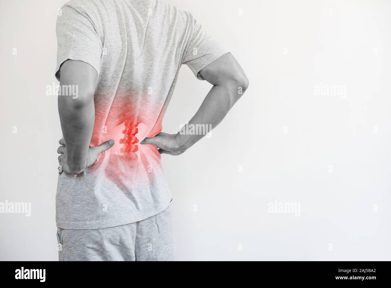 Sindrome da ufficio, mal di schiena e dolori alla parte inferiore della schiena concetto. Un uomo di toccare la sua parte posteriore inferiore al punto di dolore Foto Stock