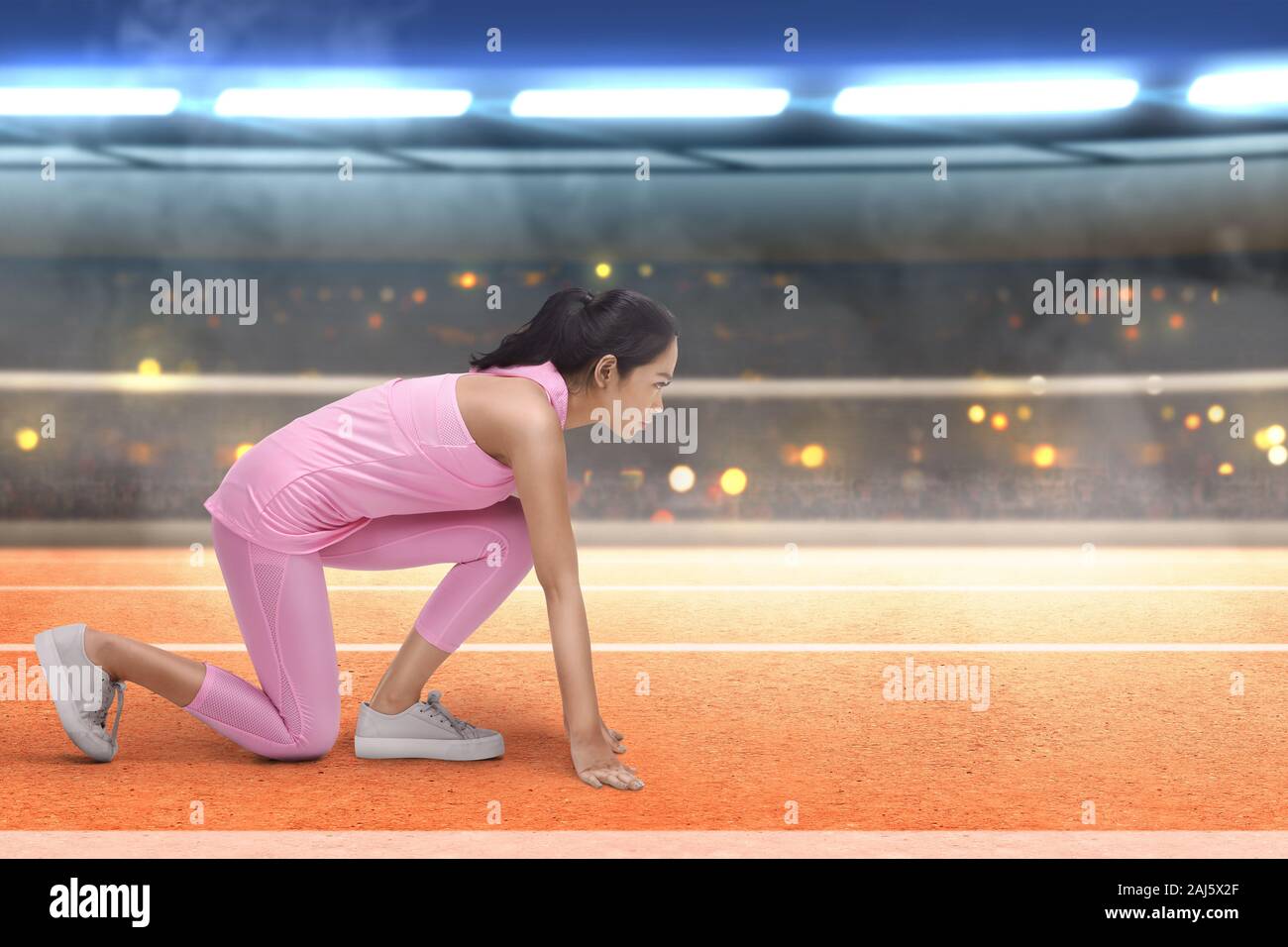 Asian runner donna pronto a correre sulla pista da corsa sullo stadio Foto Stock