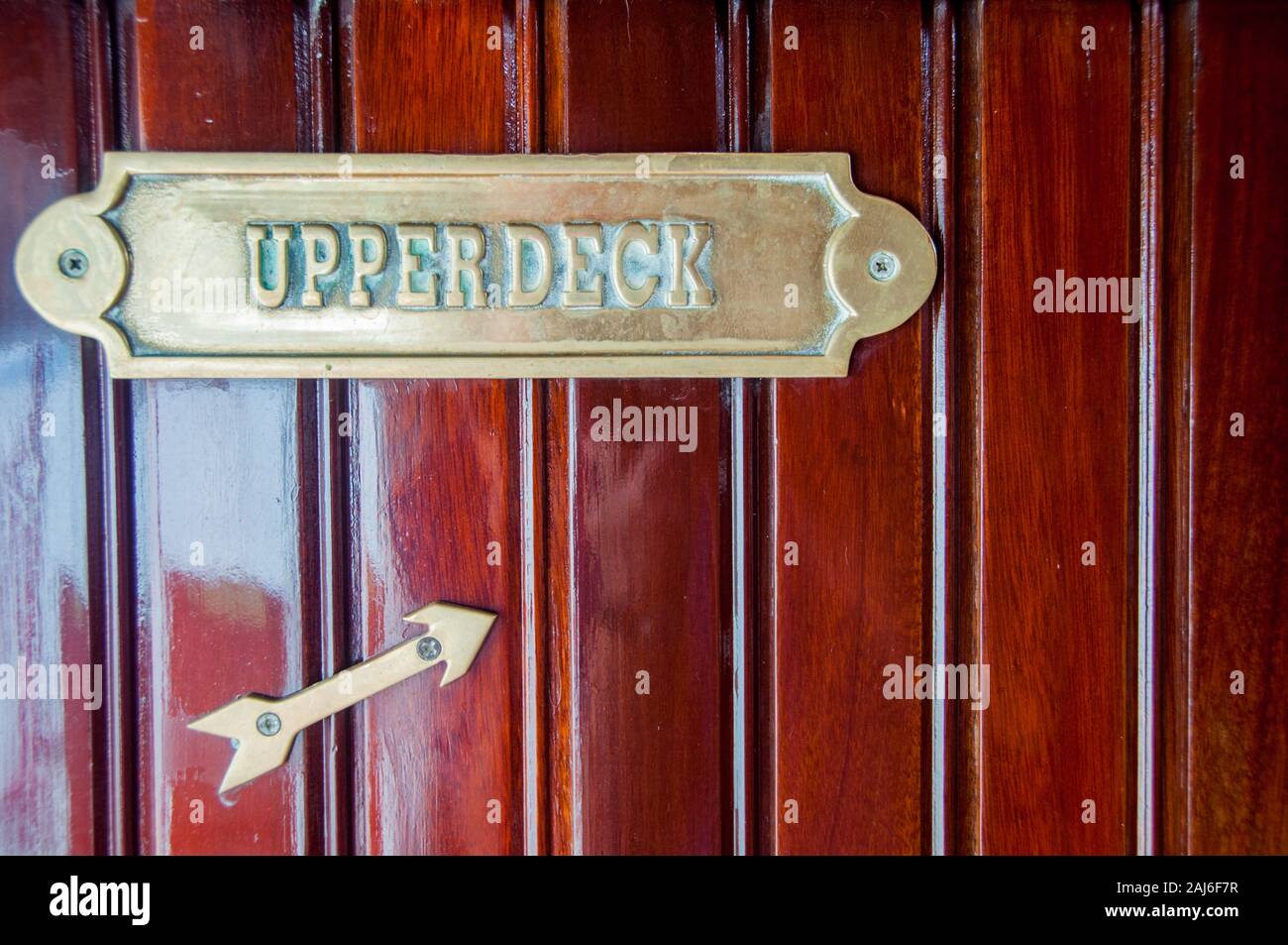 Segno di ottone che indica la direzione di ponte superiore su una nave da crociera Foto Stock