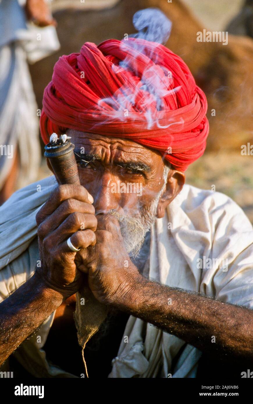 Il contadino di fumare marijuana durante il Pushkar Camel Fair, uno dei più grandi camel-mercati in Asia Foto Stock