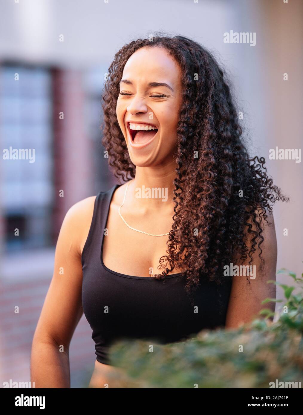 Magazzino verticale la foto di una ragazza nera di ridere e di indossare abbigliamento sportivo. Centro fitness Foto Stock