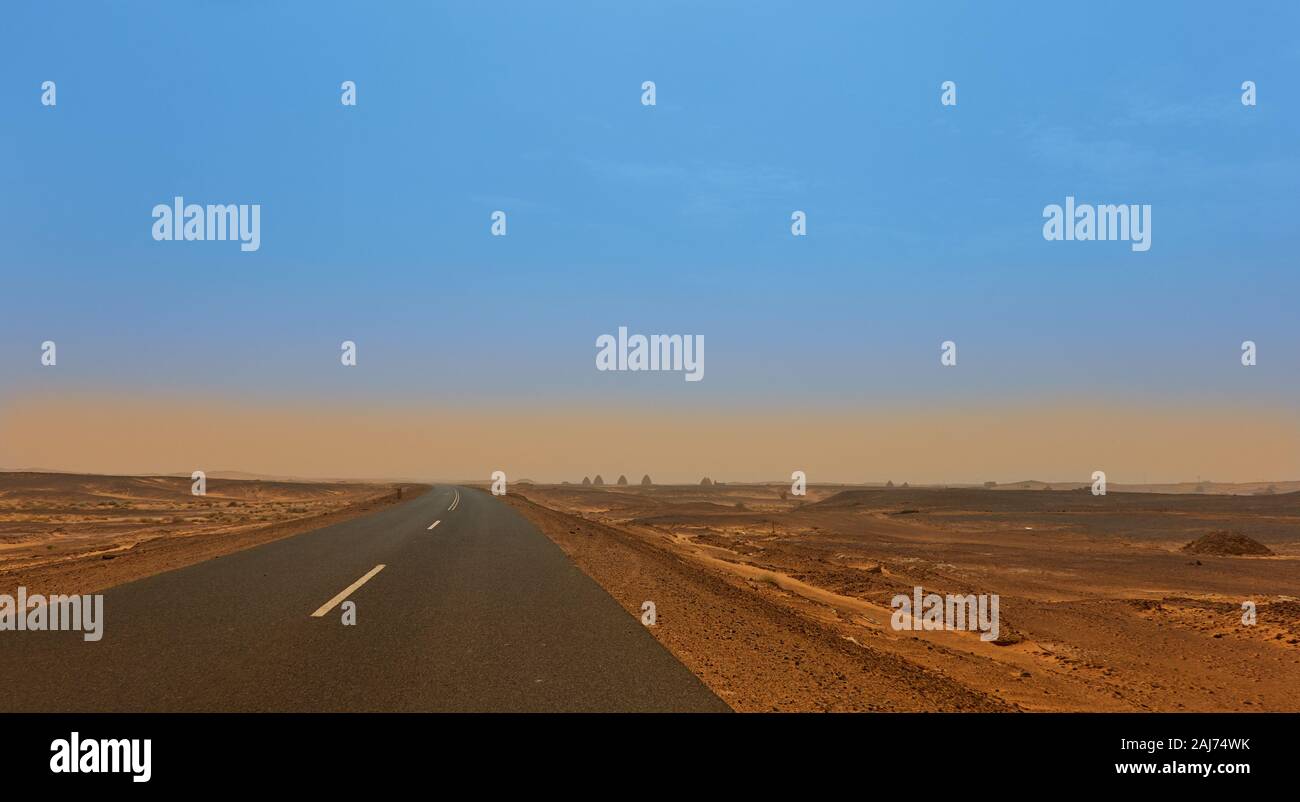 La strada attraverso il deserto del Sahara con le tombe di old dongola all'orizzonte Foto Stock