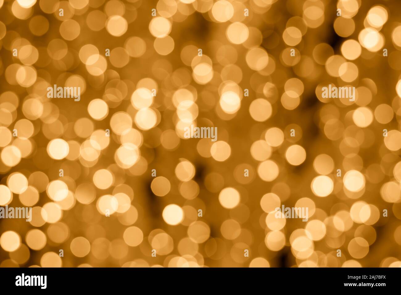 Abstract sfondo dorato con luci bokeh di fondo. Gli sfondi di illuminato. Effetto sfocato, incandescente texture, defocalizzata giallo cerchi lucido Foto Stock