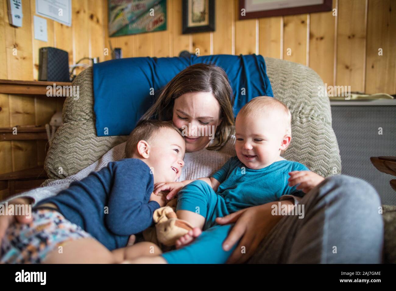 Madre affettuosamente in possesso dei suoi due figli. Foto Stock