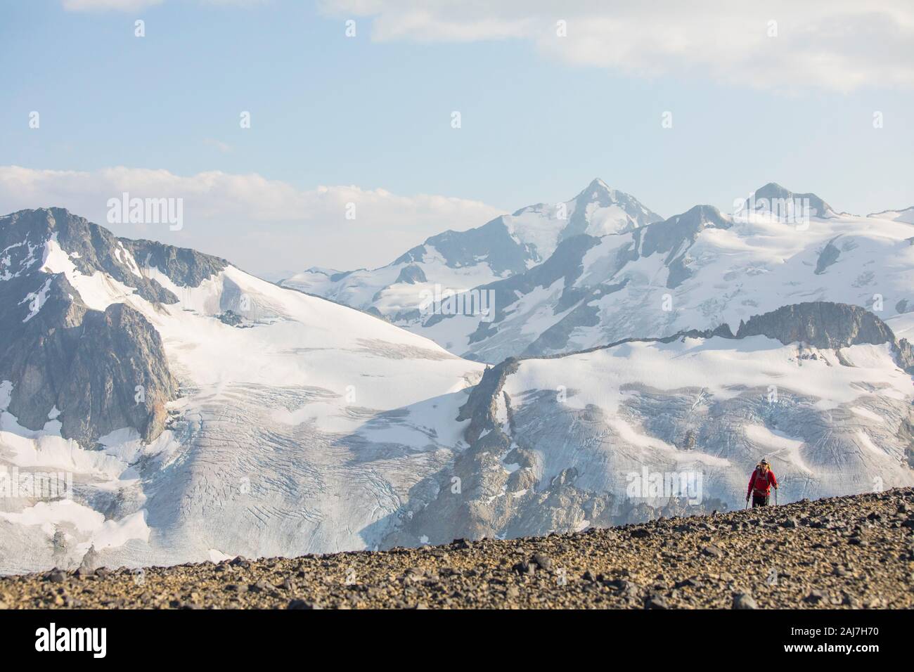 Piccolo uomo emerge sopra cresta di cresta di fronte al ghiacciaio Foto Stock