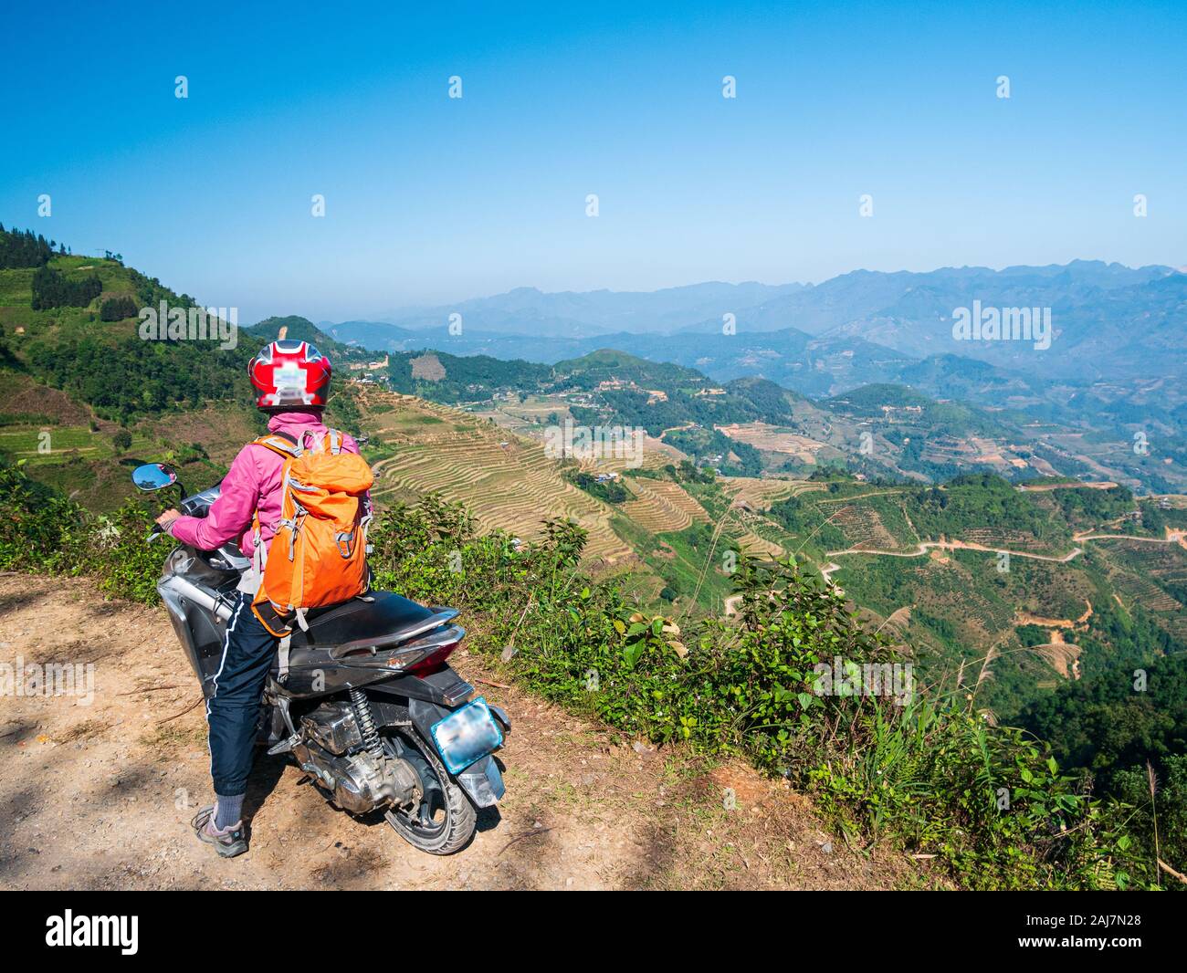 Una persona che guida la bici in ettari Giang moto loop, famosa destinazione di viaggio bikers easy rider. Ha Giang carso geoparco paesaggio di montagna nel nord vi Foto Stock