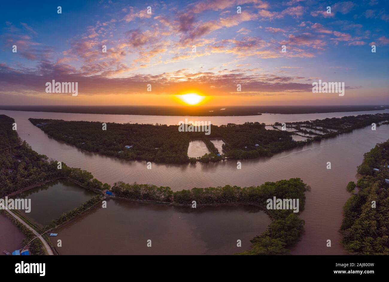 Vista aerea del Fiume Mekong Delta regione, ben tre, Vietnam del Sud. Canali di acqua e tropicali isole fluviali drammatico il cielo al tramonto. Foto Stock