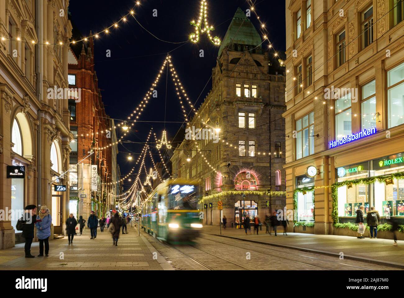 HELSINKI, Finlandia - 10 dicembre 2019: Aleksanterinkatu street di notte con il tram in movimento Foto Stock