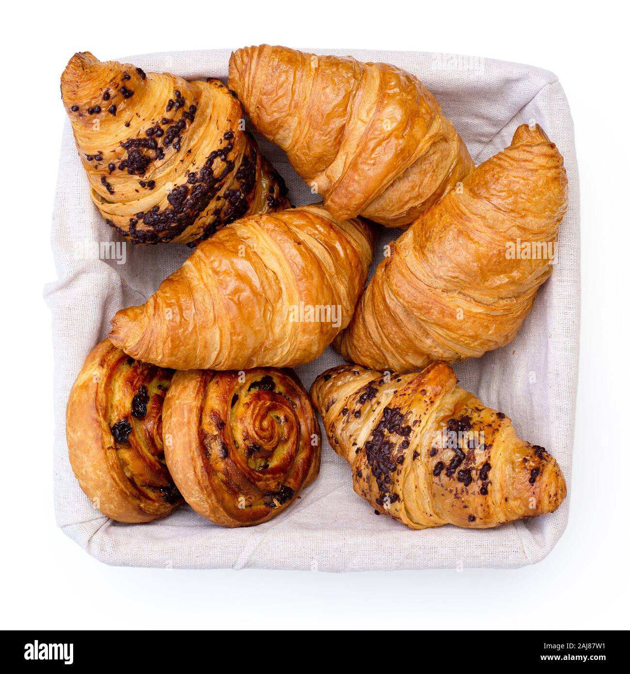In pianura e chocholate croissant e rasin pasticceria danese volute nel cesto di biancheria isolato su bianco dal di sopra. Foto Stock