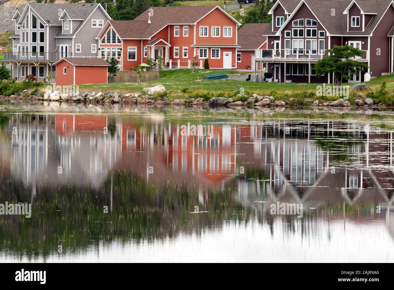 La riflessione di case a Witless Bay in Terranova e Labrador, Canada. Le facciate riflettono nella superficie dell'acqua. Foto Stock