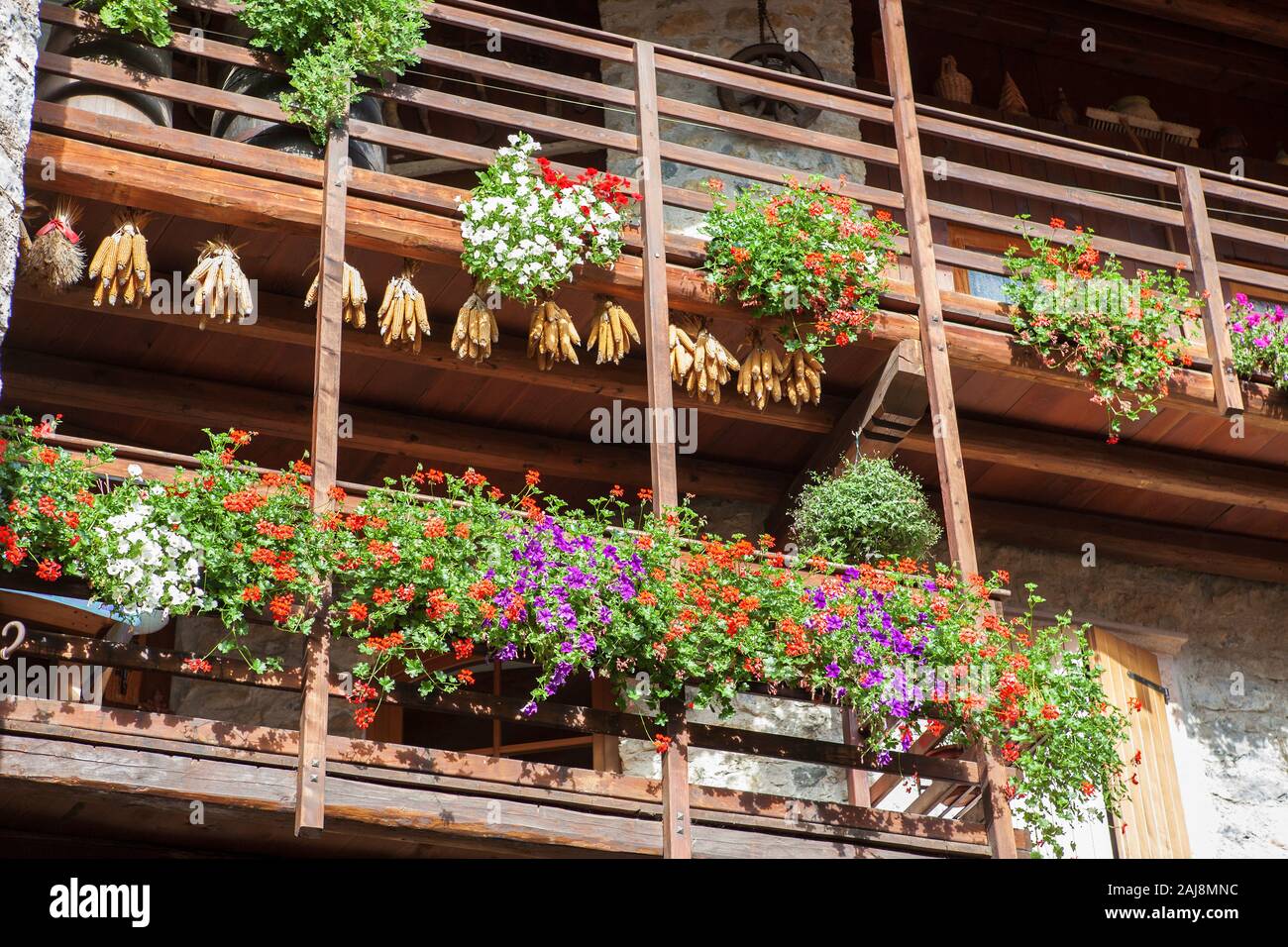 Balconi con cestelli appesi ed essiccazione di mais, Via Fratelli Bandiera, Canale di Tenno, Trentino-Alto Adige, Italia Foto Stock