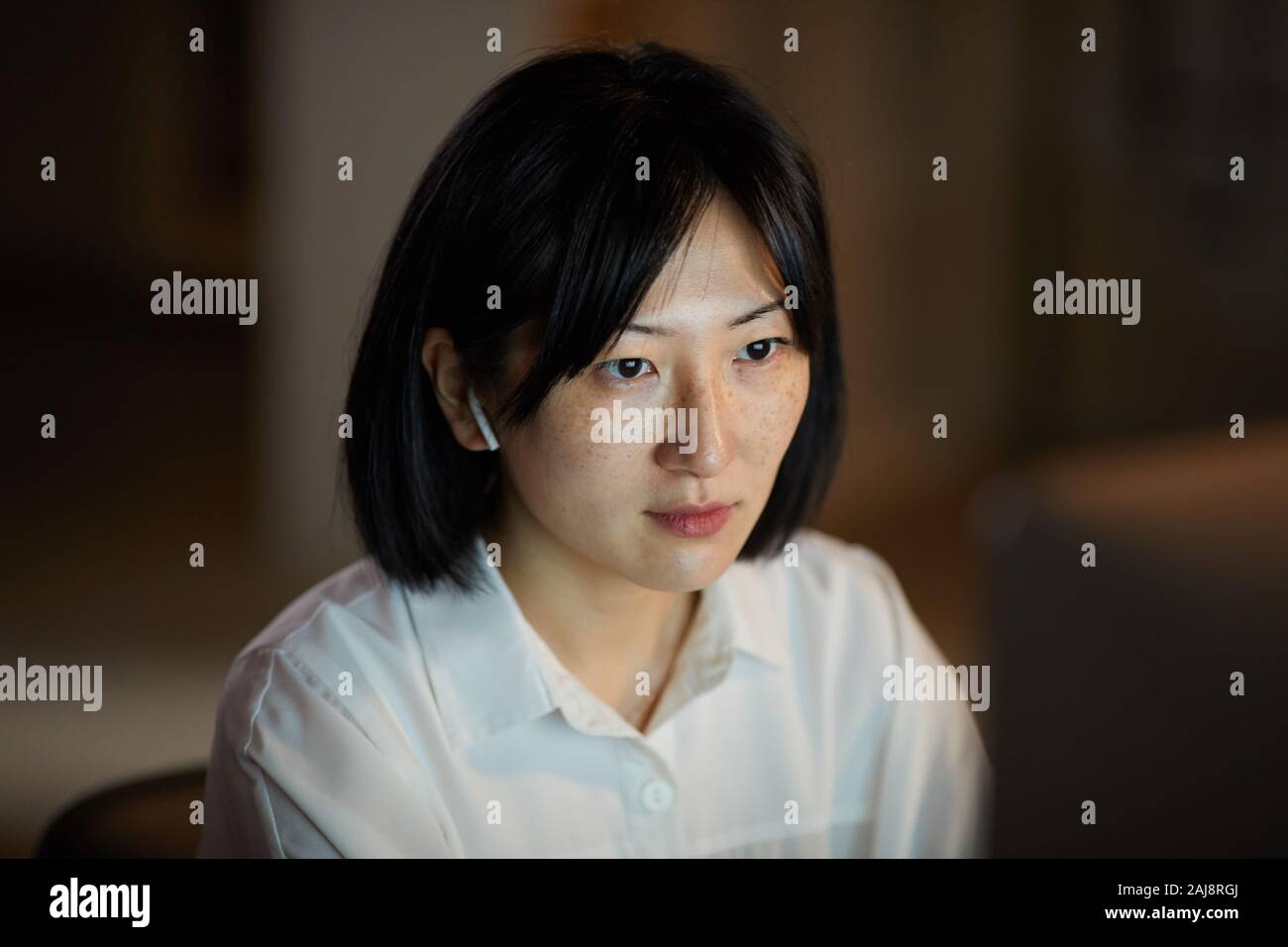 Giovane donna asiatica concentrare sul suo lavoro che lavora sul computer fino a tarda sera in ufficio Foto Stock