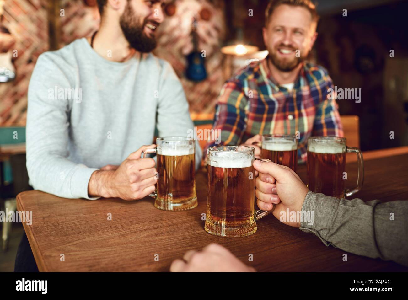 Gli amici di persone bere birra, parlare in un pub. Foto Stock