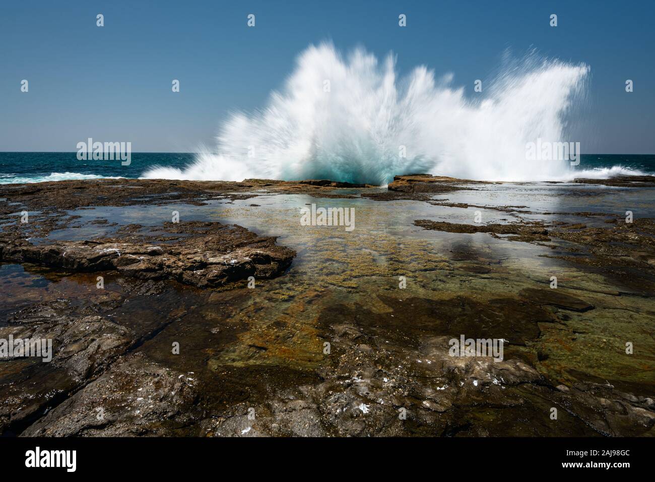 Forme d'onda colpendo la roccia altopiano a Iluka Bluff Bundjalung nel Parco Nazionale. Foto Stock