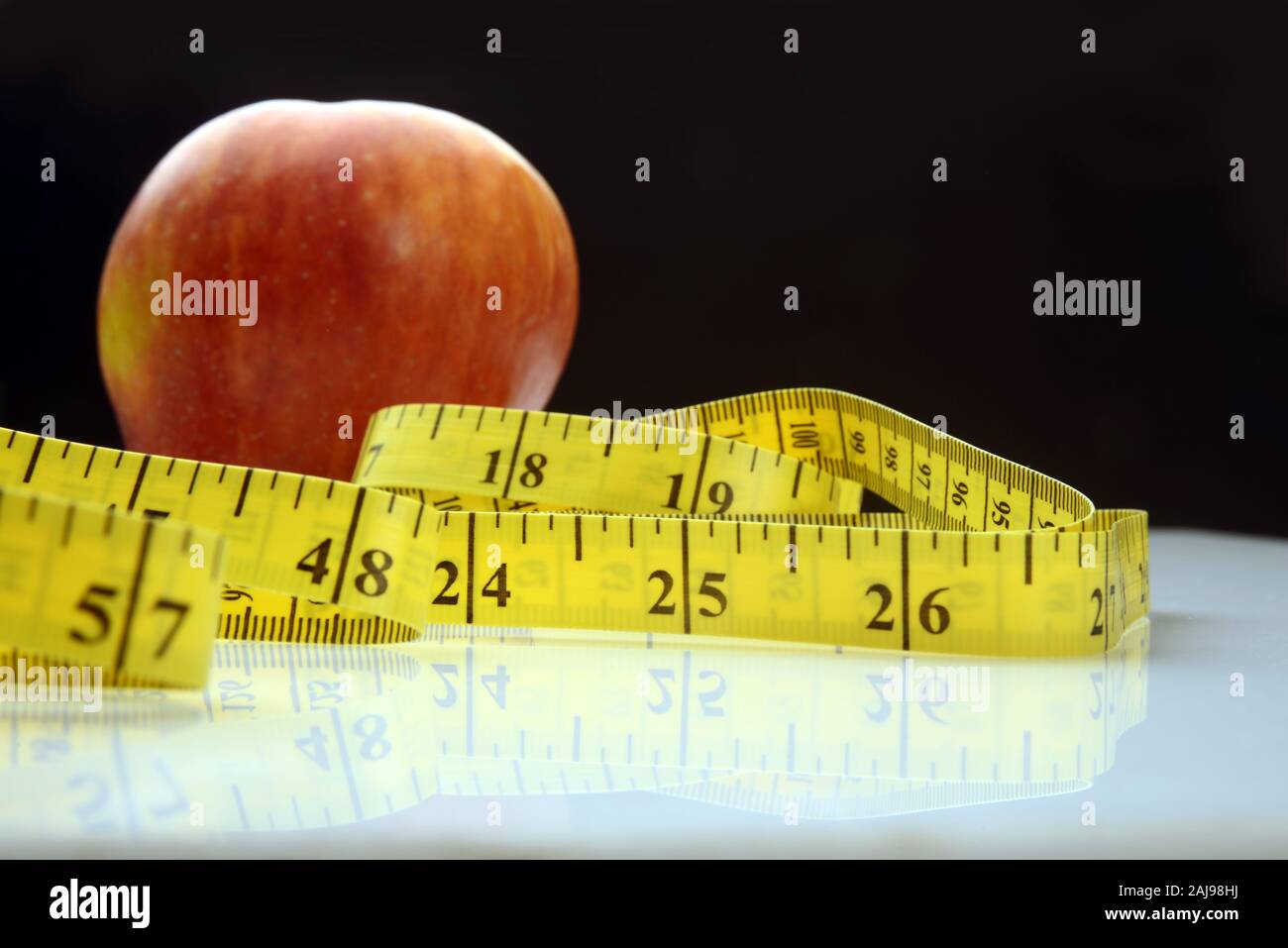 Un apple frutta con nastro di misurazione, concetto di fitness Foto Stock